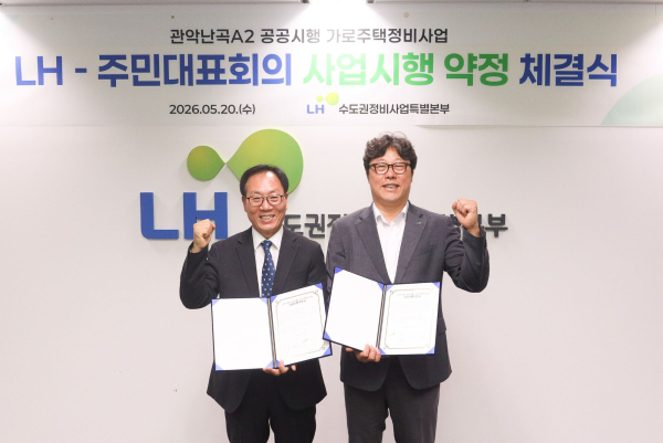 박현근 LH 수도권정비사업특별본부장(오른쪽)과 박권팔 관악난곡 A2구역 주민대표회의 위원장(왼쪽)이 협약 체결 후 기념촬영 하고 있다. [사진=LH]
